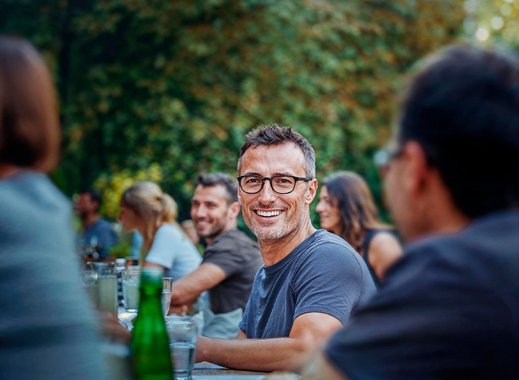 Mann mit Brille sitzt im Park